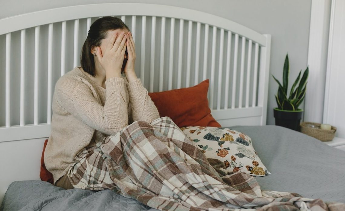 Deppresed upset tired woman sitting on bed at home. Concept of mental health. The consequences of the disease coronavirus covid-19